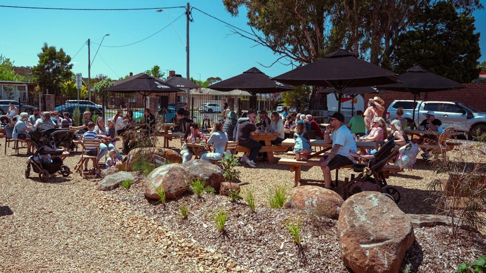 Image of guests enjoying outdoor dining with shade umbrellas