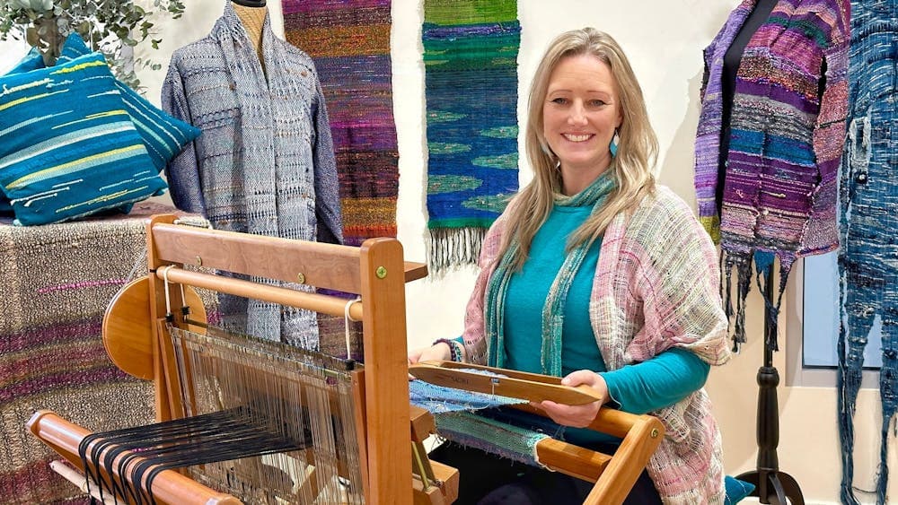 Prue Simmons of Dyeing To Weave - demonstrating the SAORI loom in front of Exhibition display