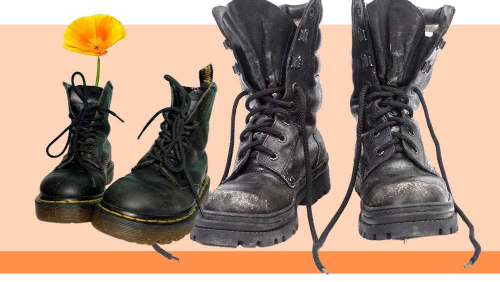 Two pairs of black boots on an orange background. The smaller pair of boots has a flower in the top.