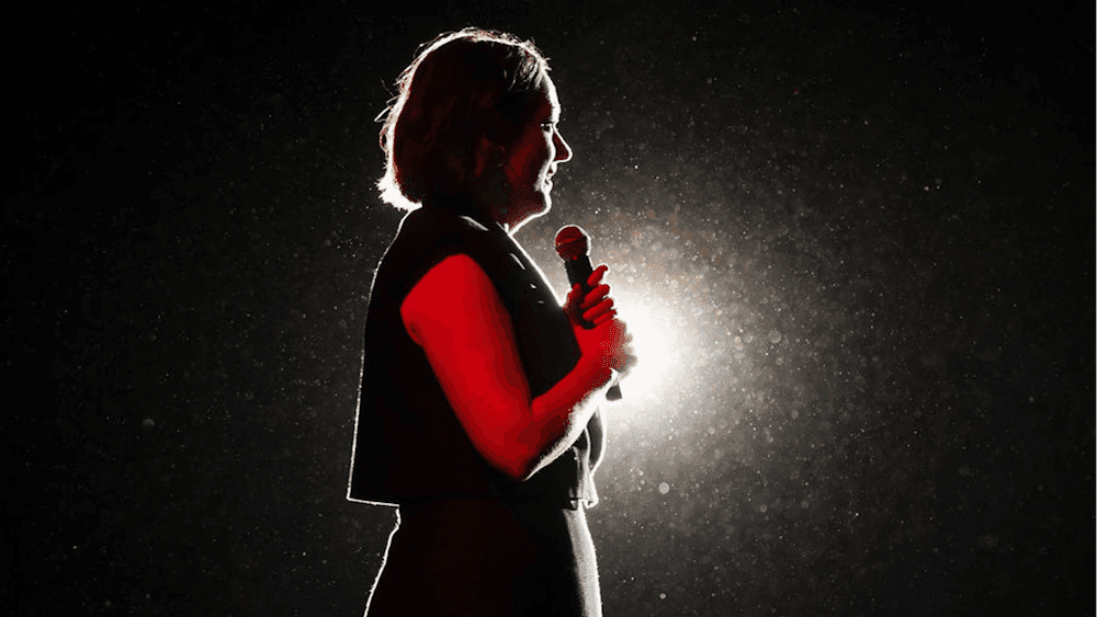 Celeste Barber on stage with a spotlight shining on her