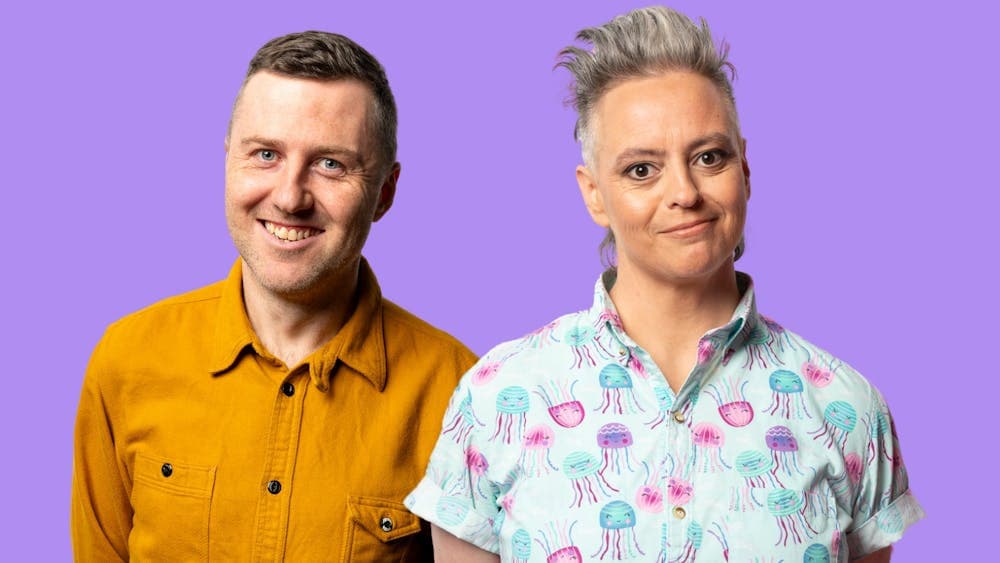 Lloyd Langford and Geraldine Hickey standing together on a lavender background