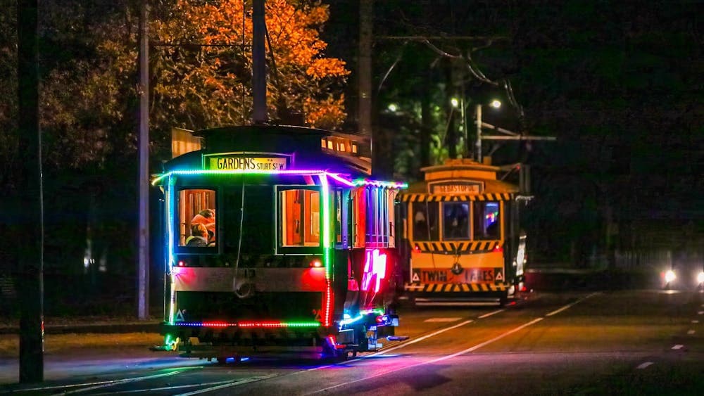 Two trams in Wendouree Parade at night