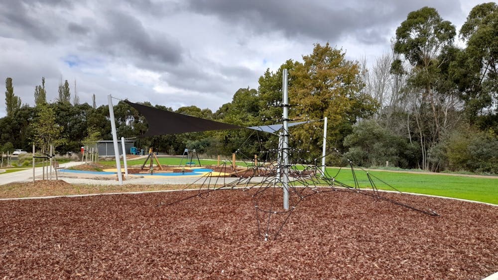 View across playground with climbing structure and play equipment