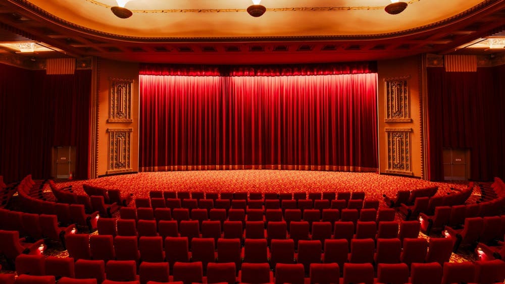 Inside of a cinema, facing the closed curtains