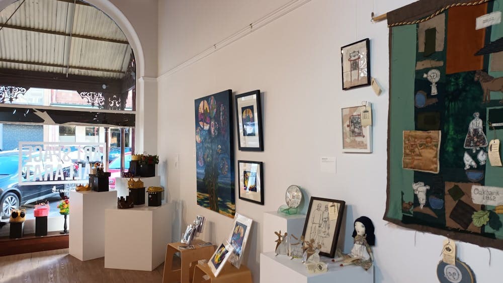 View from the back of Art Space looking towards the window with sculpture and 2D arts on the walls,