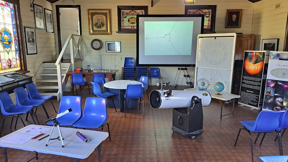 Chairs in room with rables and telescopes and a screen and white board