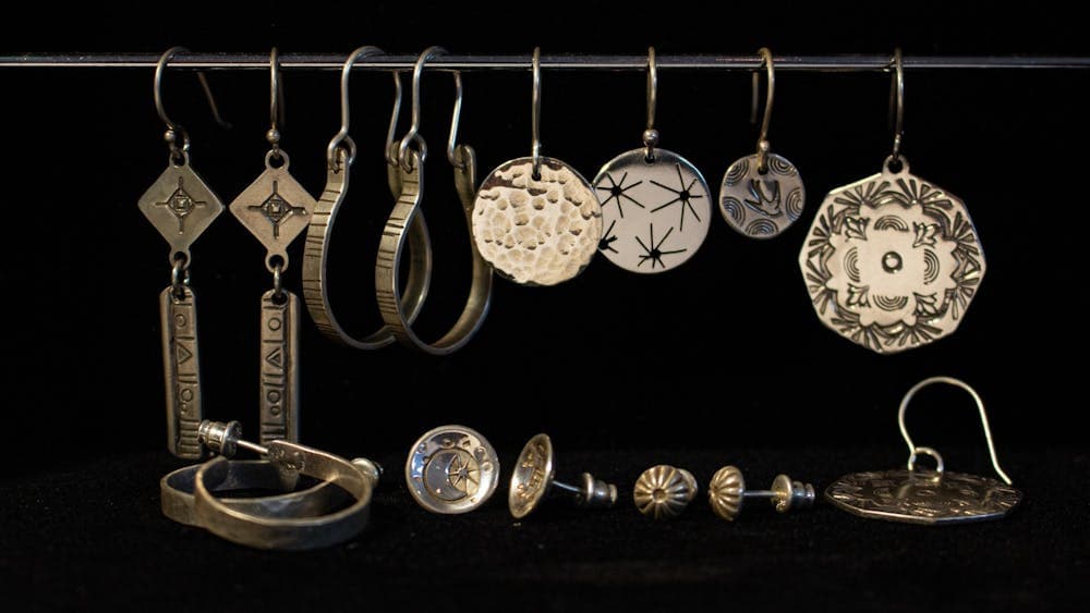 Hoop, dangling and stud earrings lined in a row