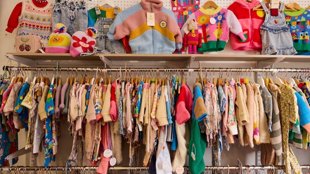 image shows brightly coloured kids clothing hanging on the racks.