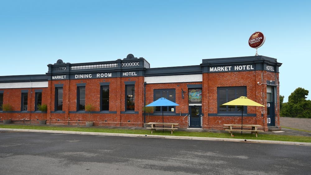 Street view of the Market Hotel. Red brick hotel with blue trim.