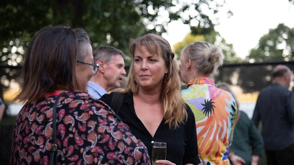 A small crowd of people chatting in a park setting