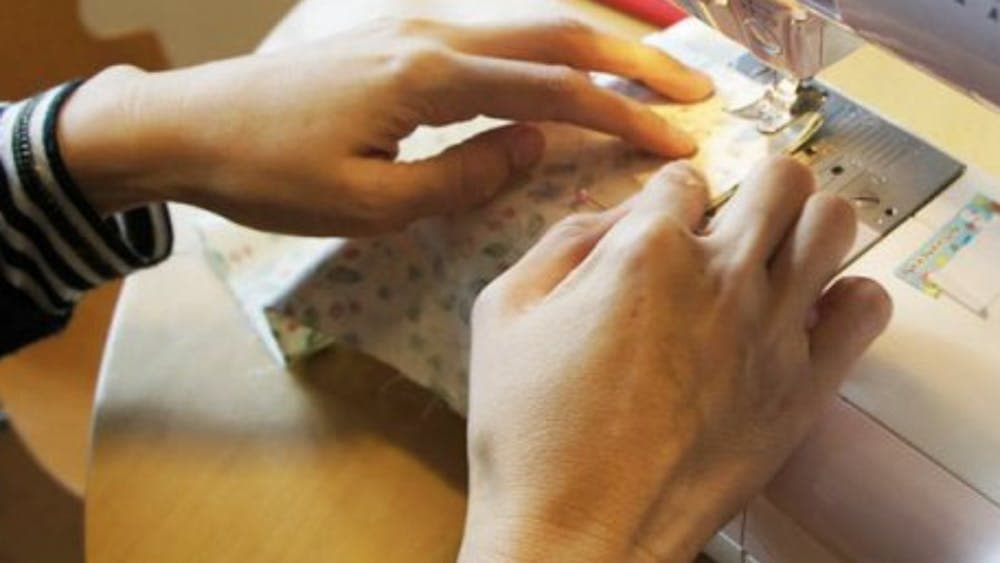 Hands sewing at sewing machine