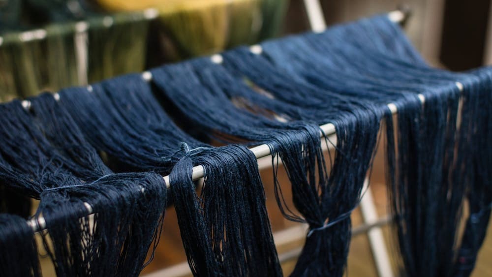 Blue yarn drying on racks