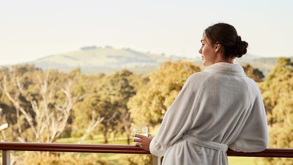 A woman enjoying the view from her Premium Fairway Suite