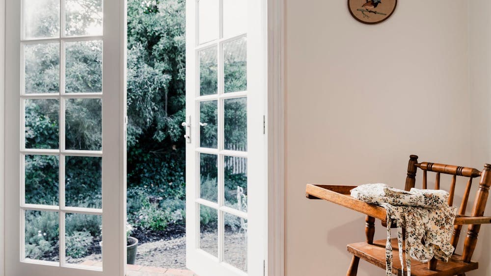 View of white French doors and children's highchair