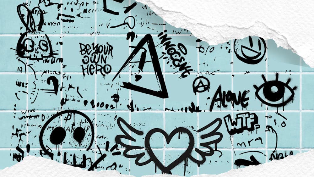 A blue tiled wall with black graffiti, covered top & bottom with torn piece of white paper.