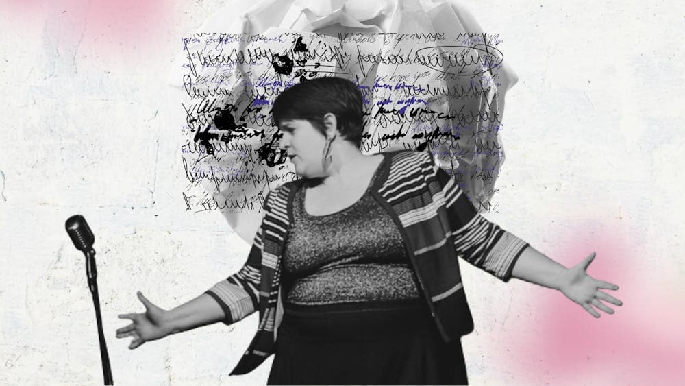 A poet performing actively with hands out in front of a mic. Background of scrunched paper & writing