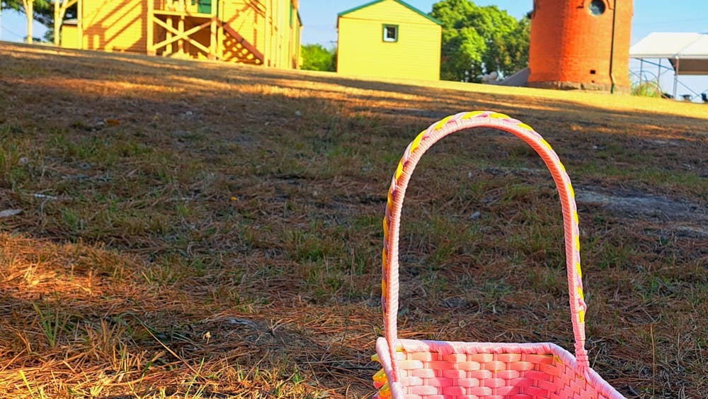 pink and yellow basket on ground in front of 2 yellow buildings and one observatory dome
