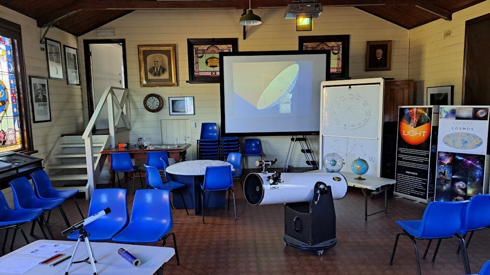 room with telescope chairs, screen moon table and whiteboard