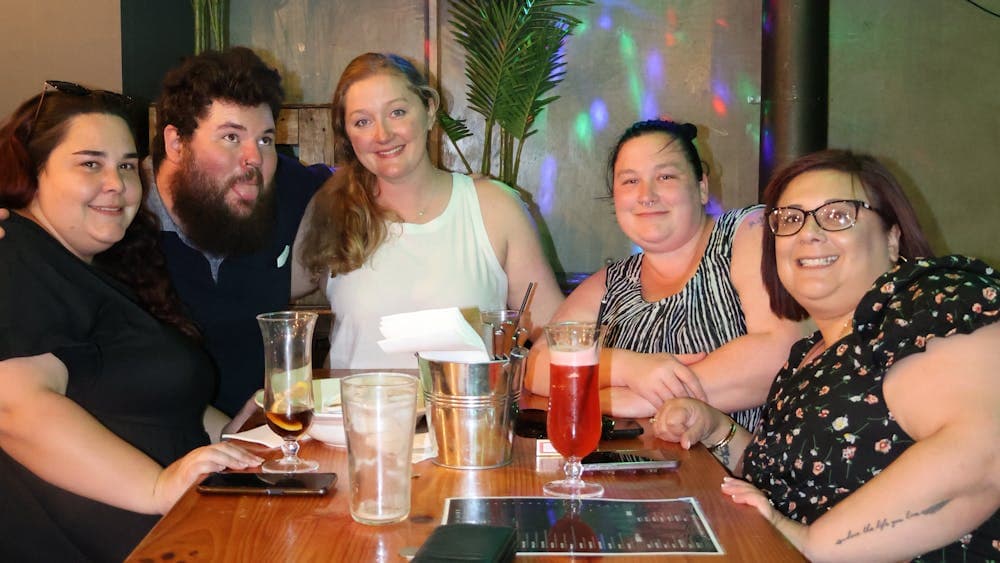 Group of friends seated at a table with drinks inside Freight Bar.