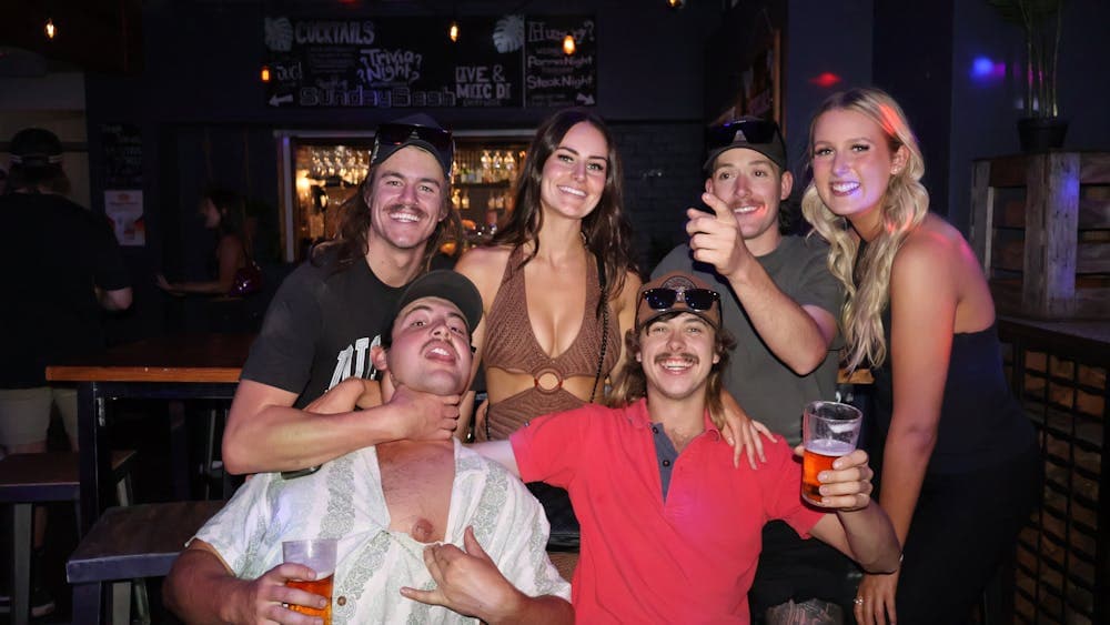 Group of friends posing with drinks inside Freight Bar.