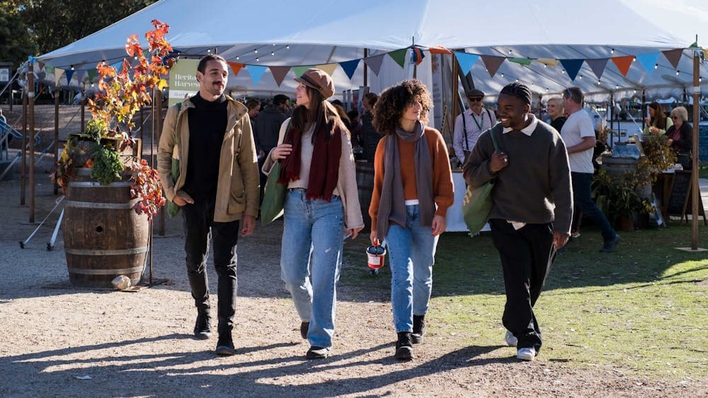 Two men and two women walking away from marquee