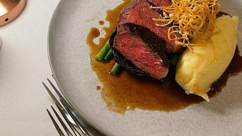 Steak with vegetables on a grey plate