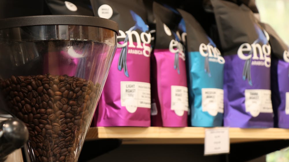 coffee beans in a machine next to packets of coffee beans