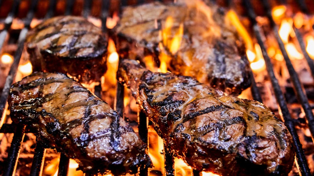 Steaks cooking on Squires Loft Ballrat's open flame grill