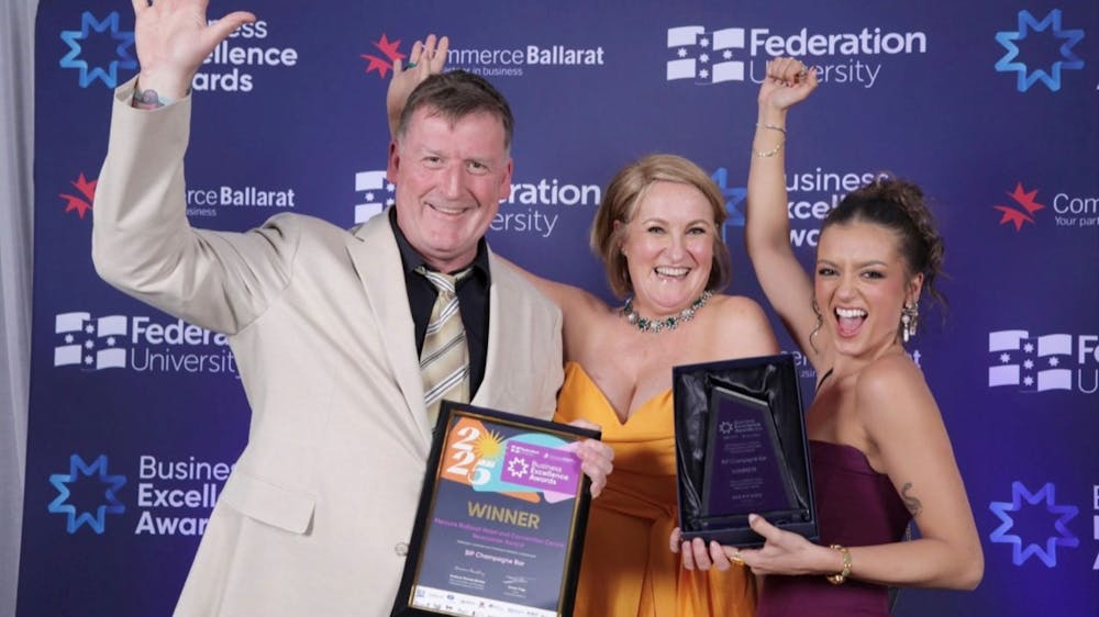 Picture of 1 man holding a certificate and two women holding a trophy