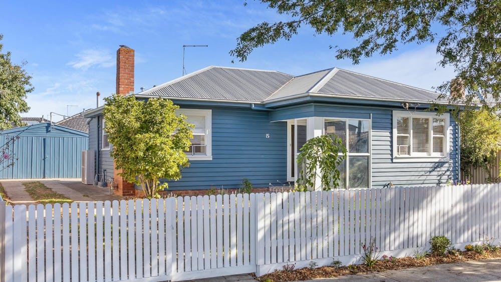 House exgterior, blue paint, white picket fence, trees and english garden