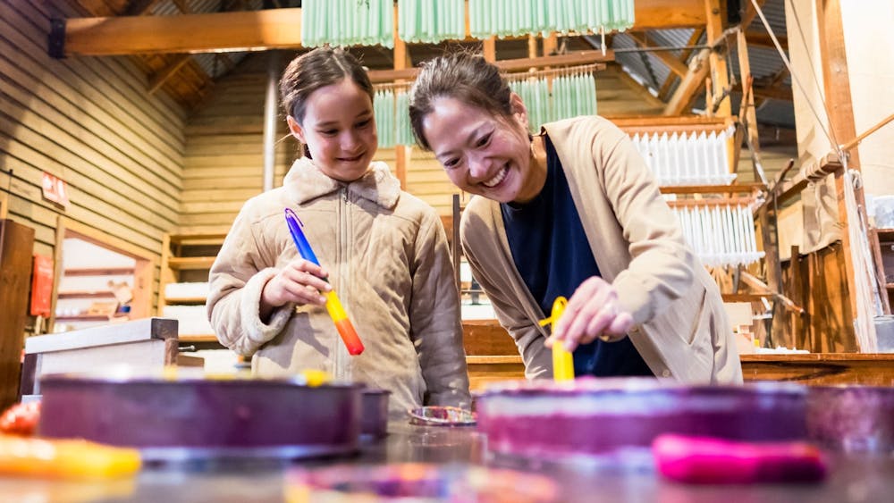 Mother and daughter dipping candles