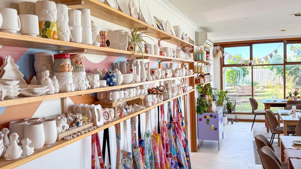 A view of four shelves filled with blank pottery items