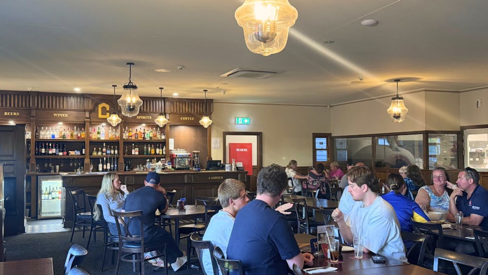 Patrons seated at tables eating and socialising inside the Courthouse Hotel dining area.