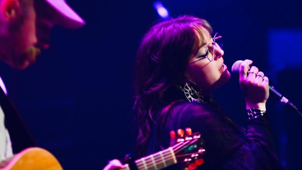 Guy on guitar and young woman singing her heart out