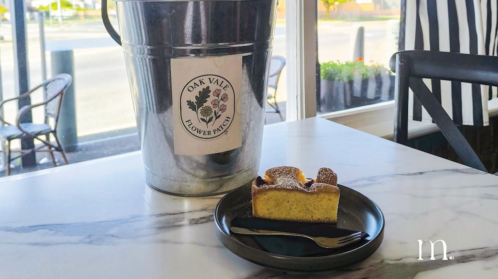 A bucket of flower bouquets and slice sitting on a table
