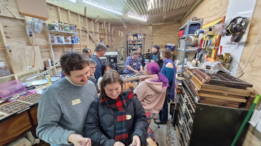 group of people working with letterpress in a studio