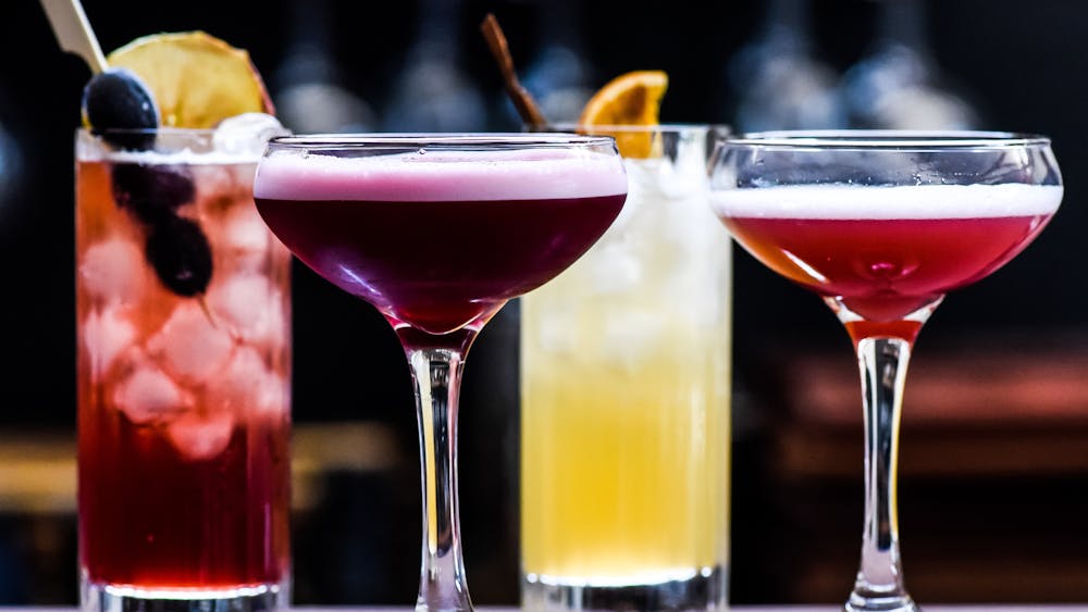 A row of colourful cocktails in different shaped glasses