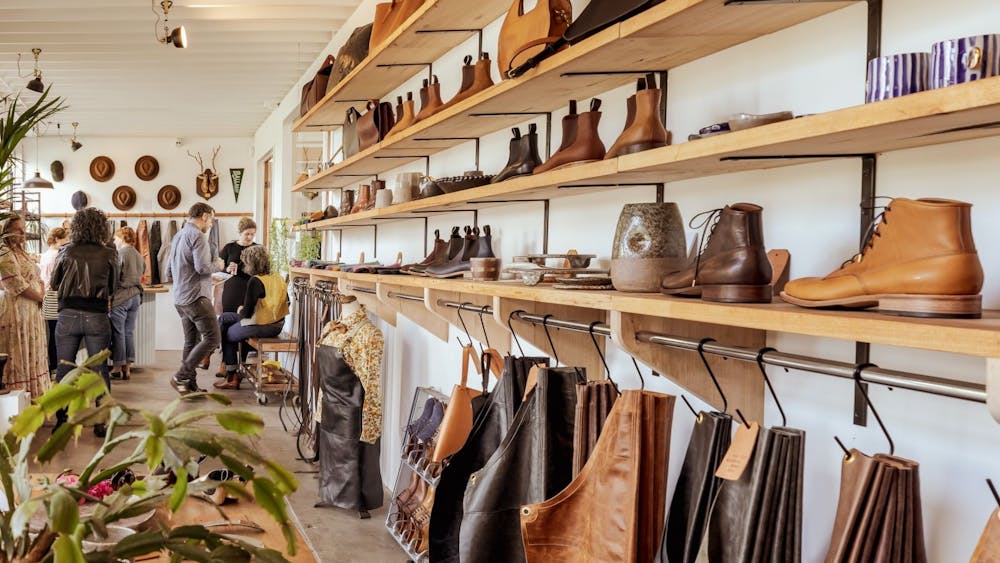 Shop shelving with boots, ceramics, aprons and people browsing