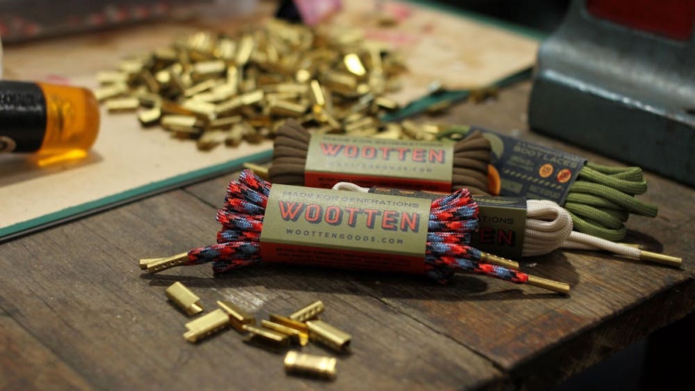 Shoe laces in their packaging with brass aglets across a table