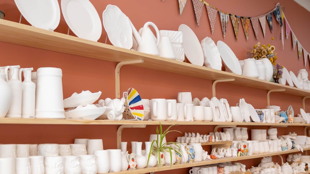 Wall of pottery items to choose form when attending a painting workshop.