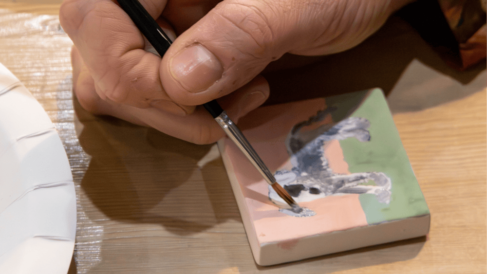 Customer painting a ceramic tile