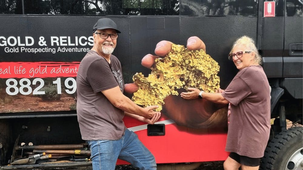 Visitors gathered in front of the Gold & Relics bus at a goldfields tour location.