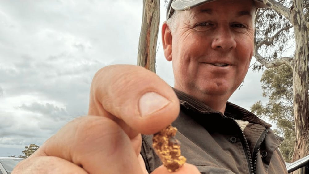 Happy prospector holding freshly discovered gold in the Victorian goldfields.