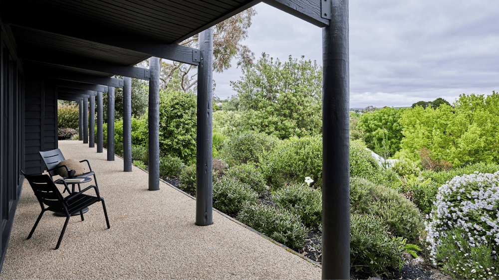 Jumoku Verandah with black chairs looking out onto the green bushes in the garden