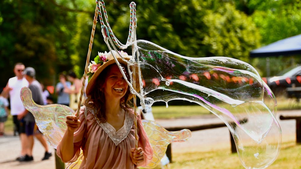 Woman dressed as a fairy with big bubble wand and bubble