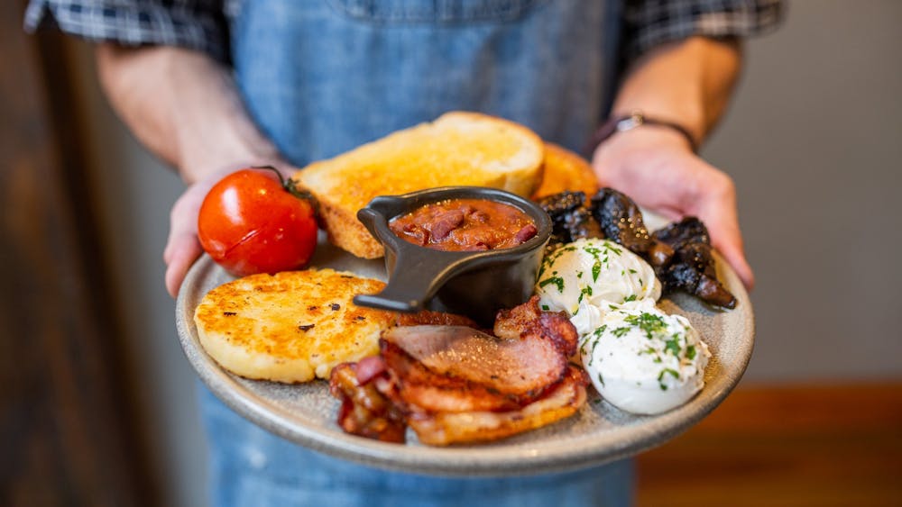 Staff member carrying Webster's signature cooked breakfast.