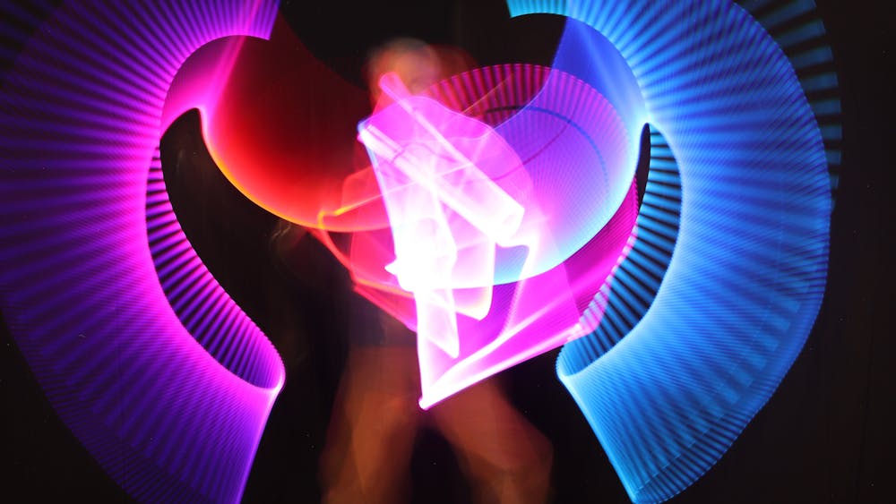 Bright patterns in blue, purple and red draw with light, captured by a photographer .