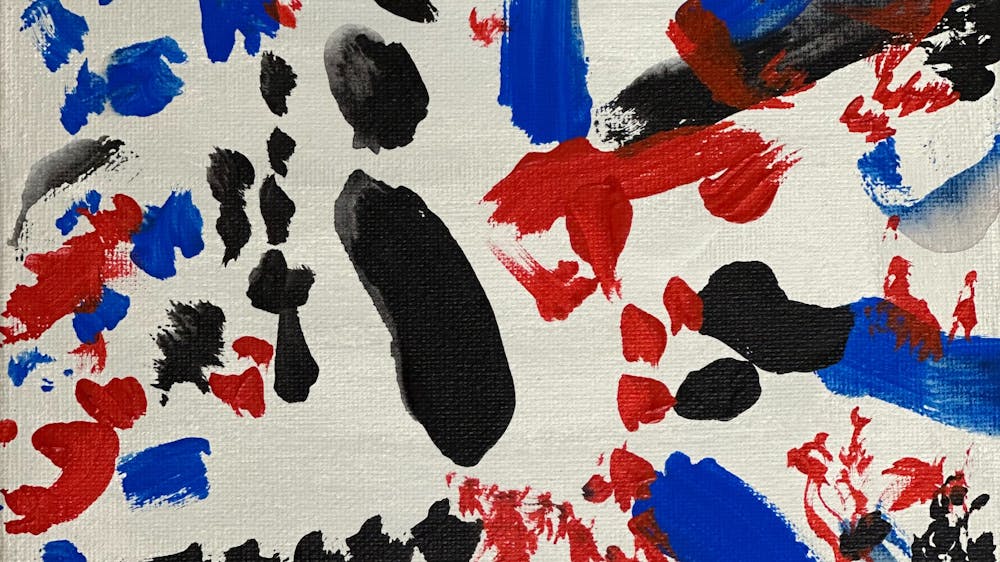Blue, red and black markings on a white background creating an abstract work.
