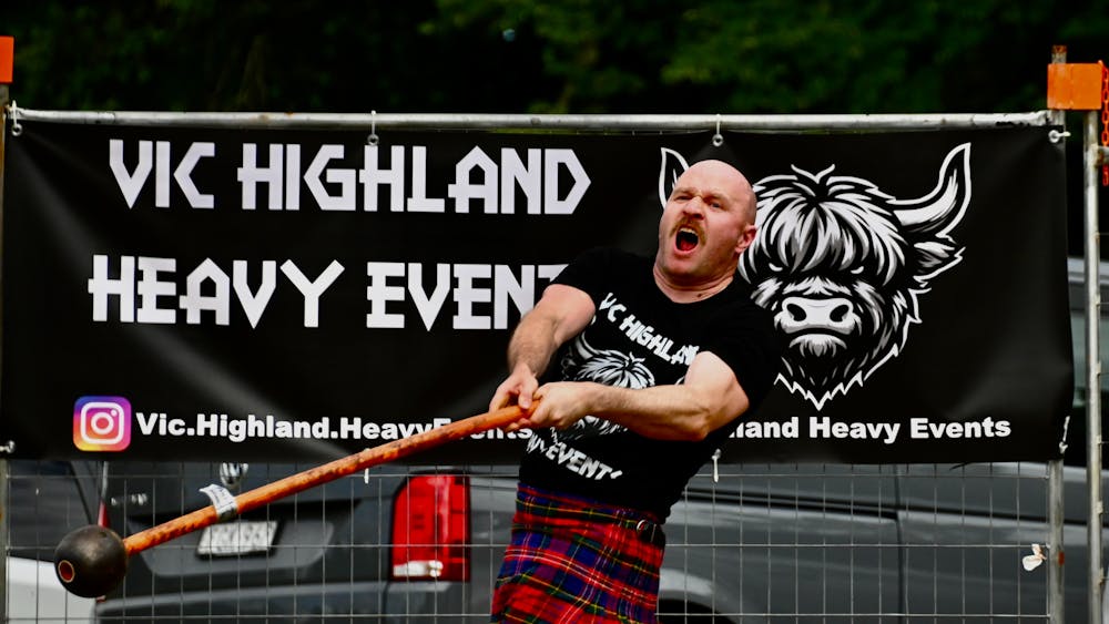 Highland games athlete in red kilt competing in Hammer Throw event
