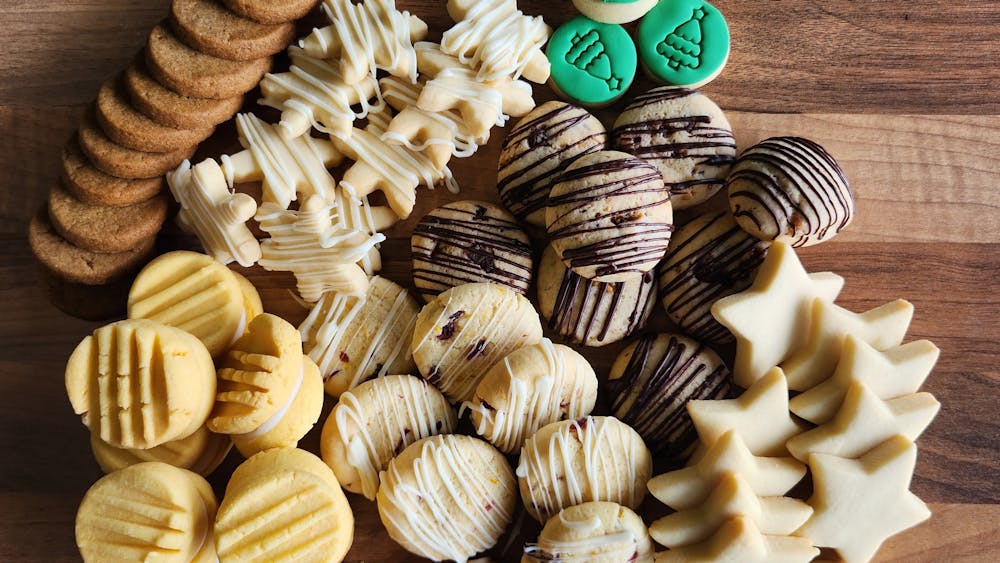 Biscuits payed out on wooden bench showing seven types of biscuits with at least 6 of each type
